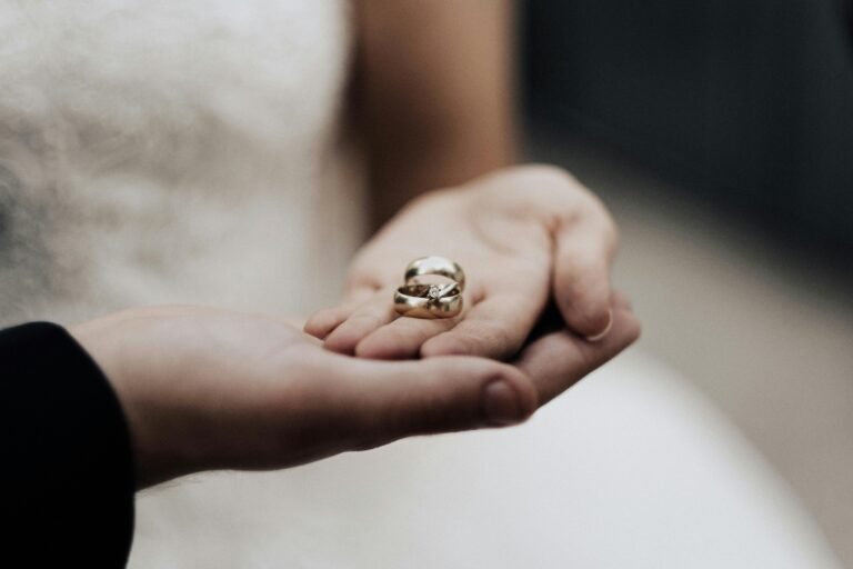 Bride holding wedding bands in a tender moment, symbolizing love and commitment.